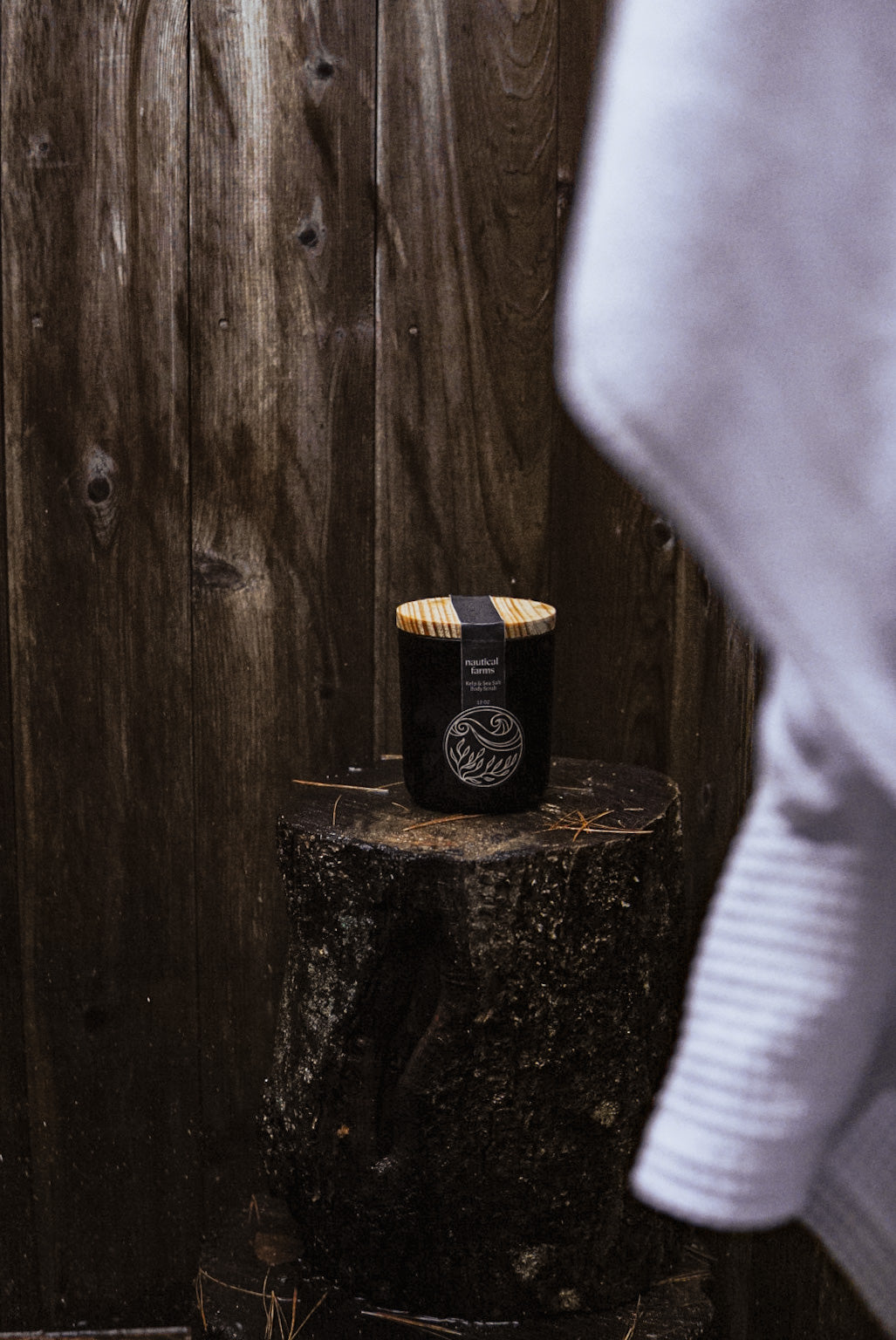 Kelp-infused sea salt body scrub with lemongrass scent. Natural exfoliant and moisturizer from Maine Seaweed Company Nautical Farms. 12 oz comes in reusable black matte jar with raw wood lid.