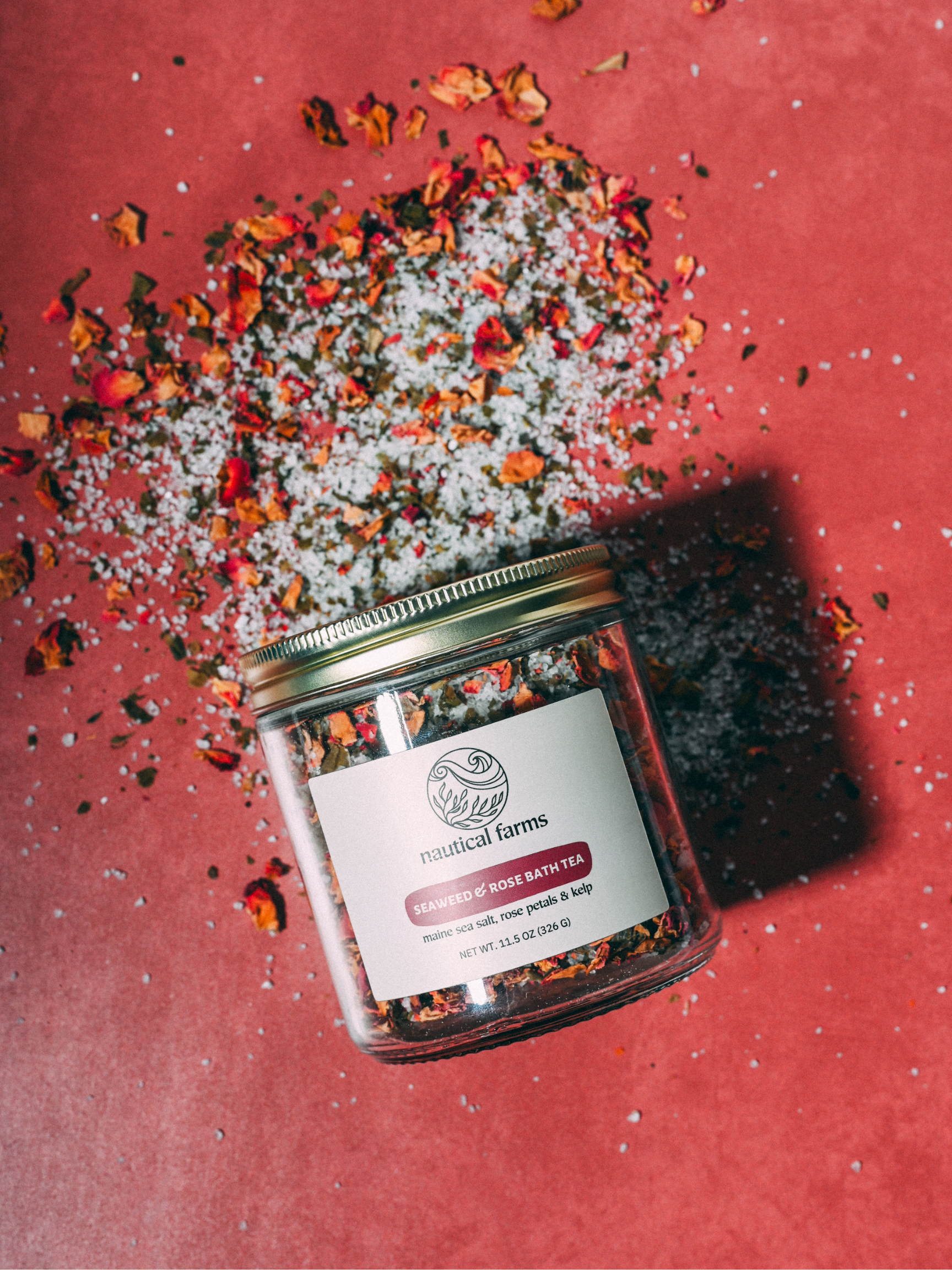 Jar of dried roses, sea salt and organic kelp with a visible Nautical Farms brand label on a red background
